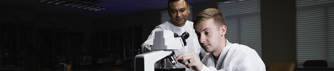 巴克特教授一边使用显微镜一边教学生。